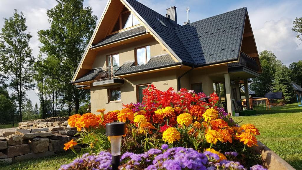 una casa con un mazzo di fiori davanti di Dom na skraju lasu a Jurgów