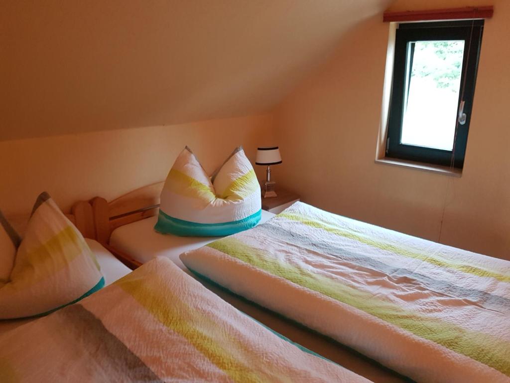 1 Schlafzimmer mit 2 Betten mit Kissen und einem Fenster in der Unterkunft Havel-Pension Kruse in Havelberg