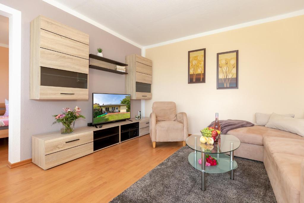 a living room with a couch and a tv and a table at Bungalow Becker "Am Feldrand" in Jennewitz