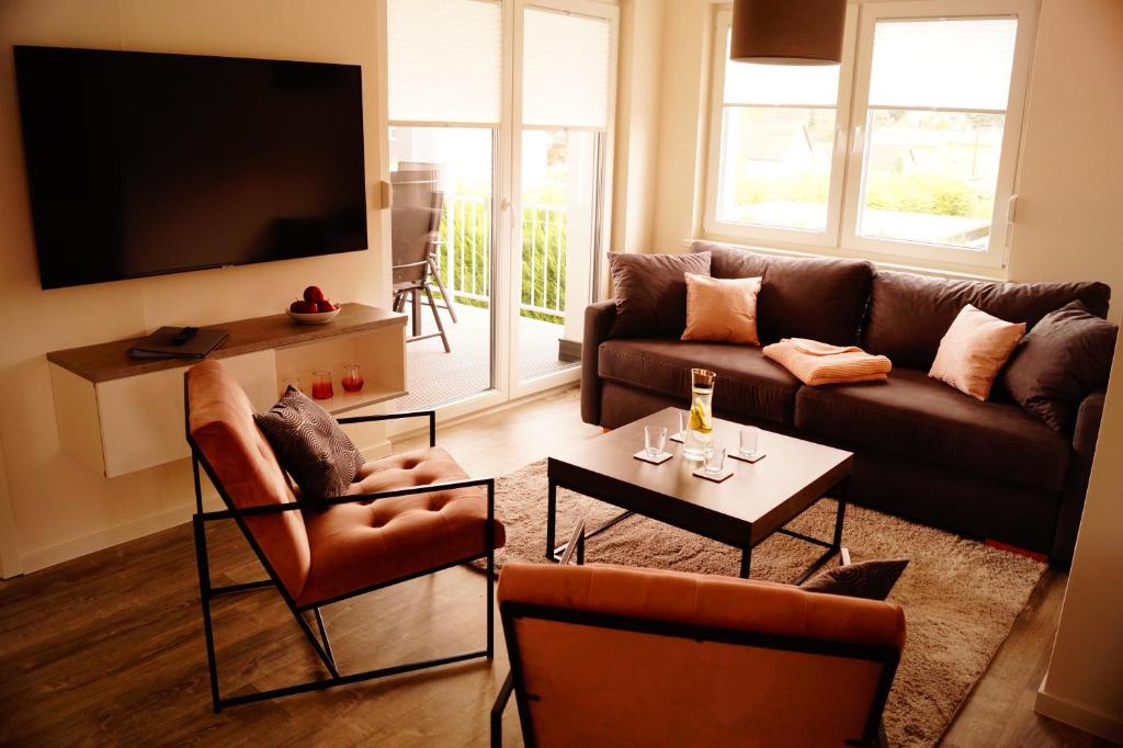 uma sala de estar com um sofá e uma televisão em Lausitzer Edelquartier em Großkoschen