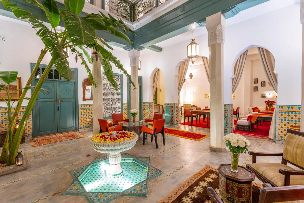 Riad Azahar في مراكش: غرفة معيشة مع طاولة وكراسي