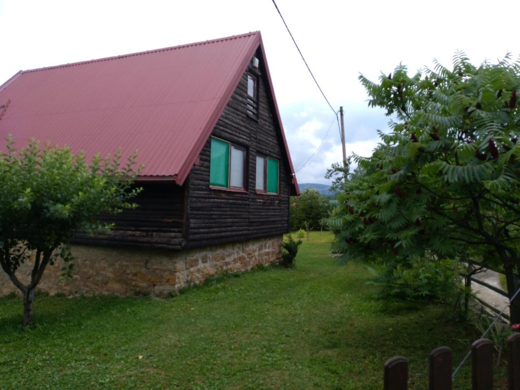 una casa con techo rojo y ventanas verdes en Vikend kuća Elmina Gorani VISOKO, en Visoko