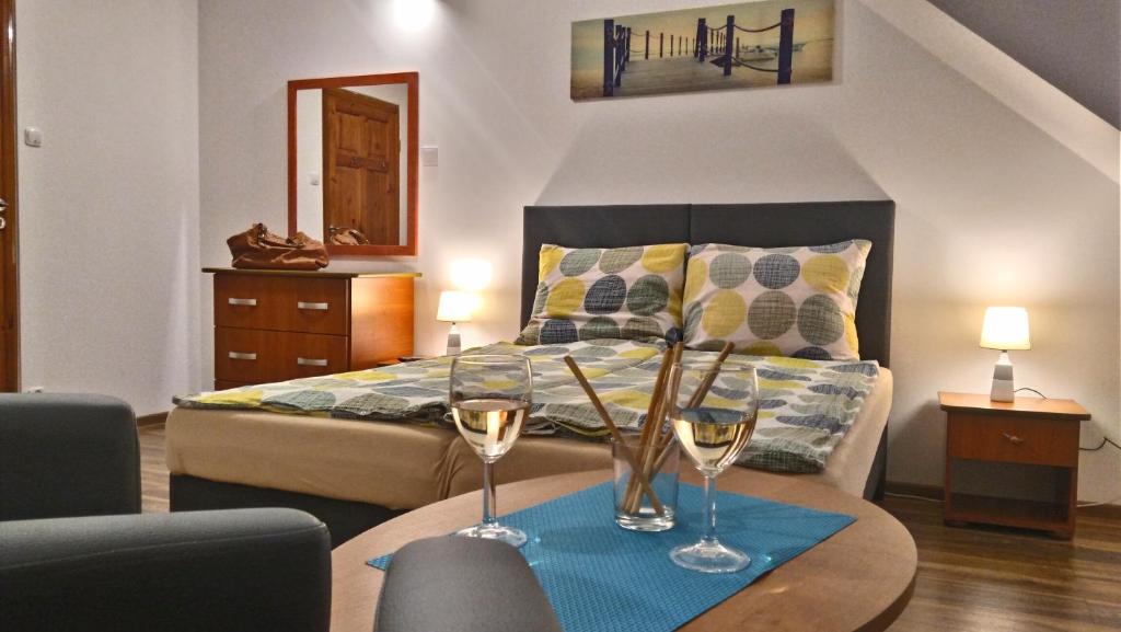 een slaapkamer met een bed en twee glazen op een tafel bij Domus in Ustka