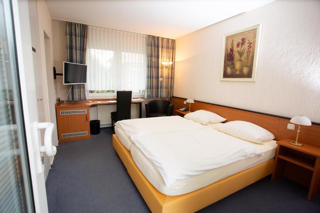 a hotel room with a bed and a desk at Gästehaus Am Vogelsang in Kerpen