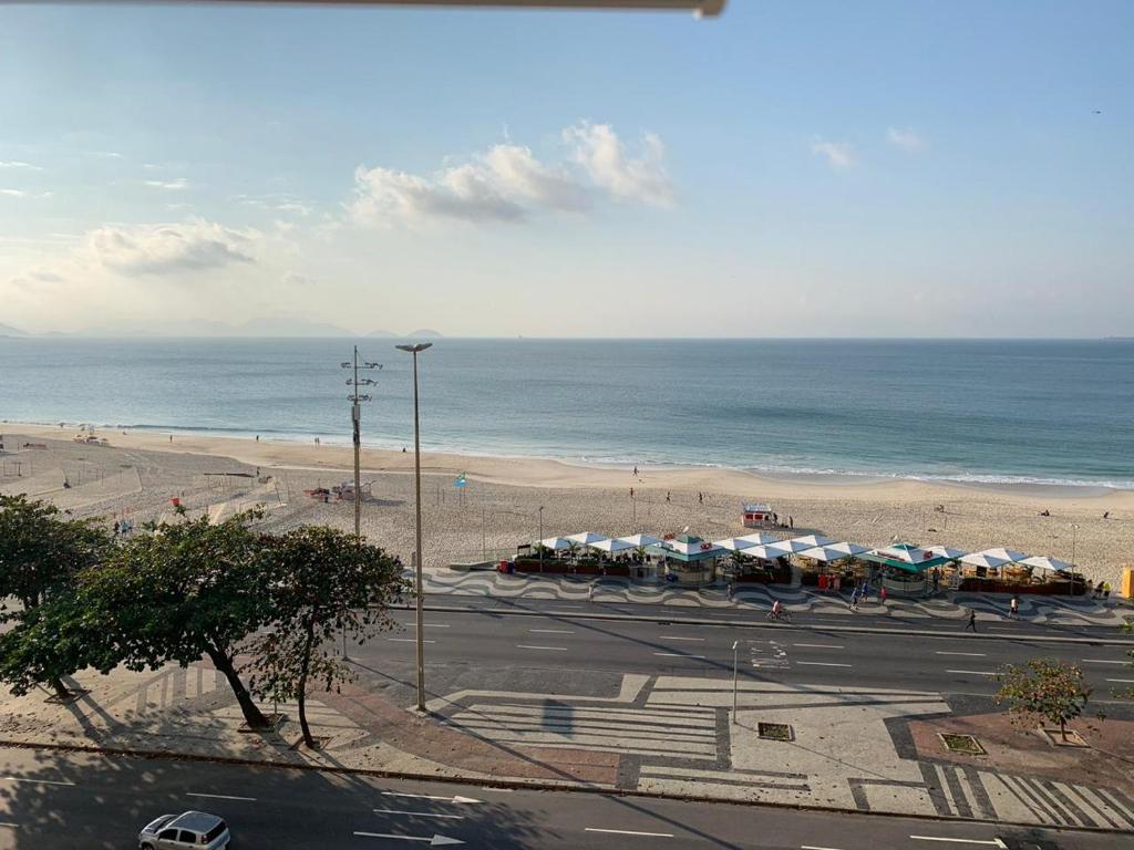 a view of a beach with umbrellas and the ocean at Studio Atlântica II in Rio de Janeiro