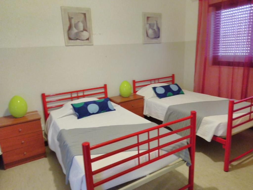 1 dormitorio con 2 camas y ventana en Mussiene House - CPSBM, en São Bartolomeu de Messines
