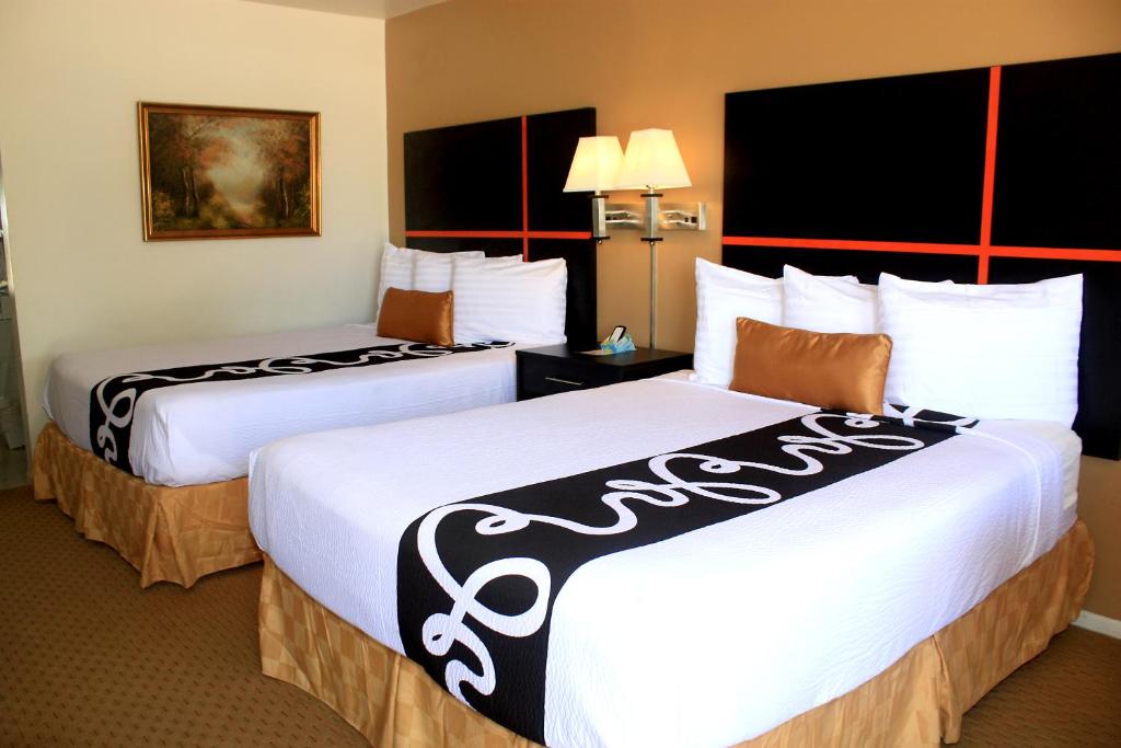 a hotel room with two beds with white sheets at Chaparral Motor Inn in Burlington