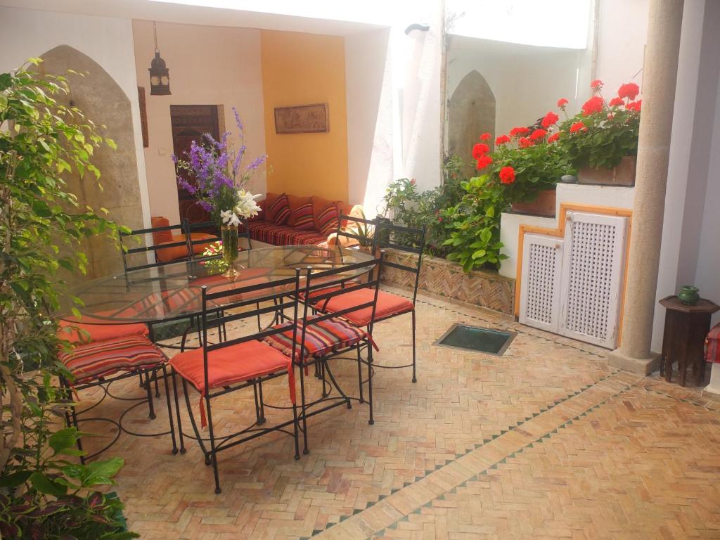 - un groupe de chaises et de tables dans une pièce fleurie dans l'établissement Darmimouna, à Assilah