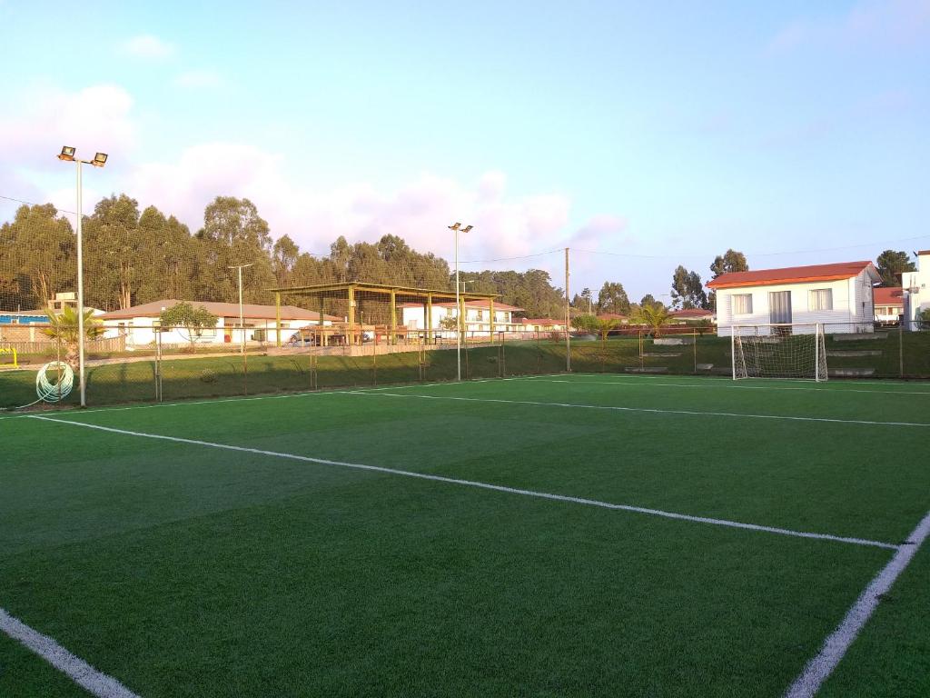 una pista de tenis verde con una red en Centro Turistico El Quisco, en El Quisco