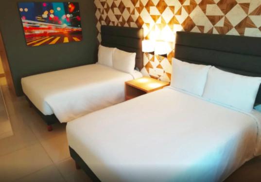 Habitación de hotel con 2 camas y una foto en la pared en Hotel Urbainn en Veracruz