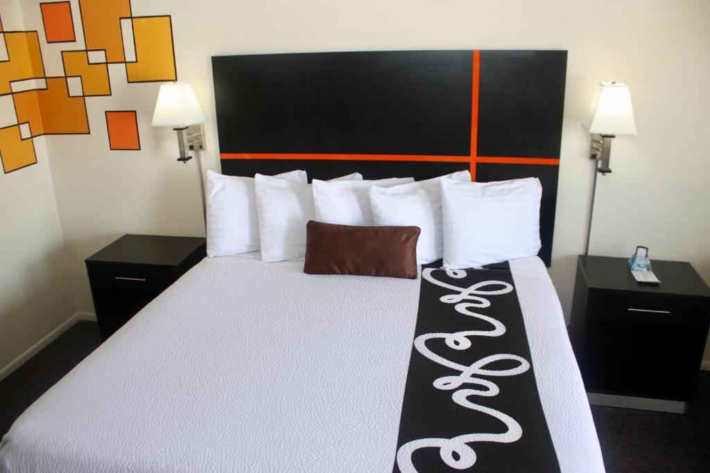 a hotel room with a large bed with white pillows at Chaparral Motor Inn in Burlington
