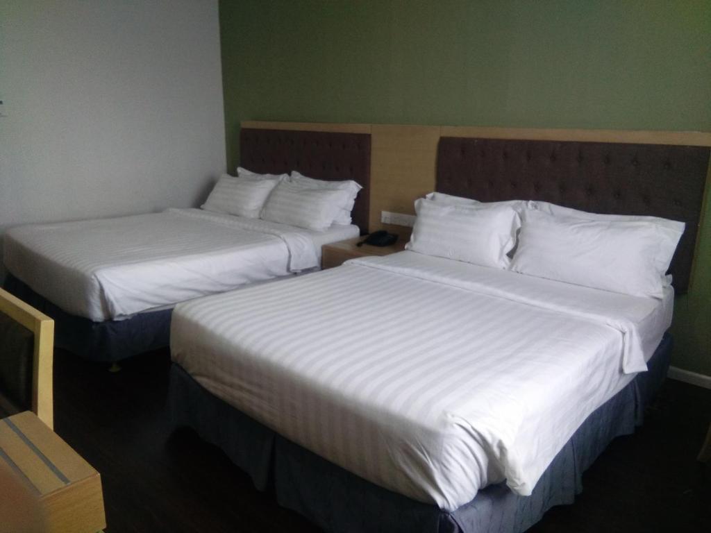 Postel nebo postele na pokoji v ubytování Seri Simanggang Hotel