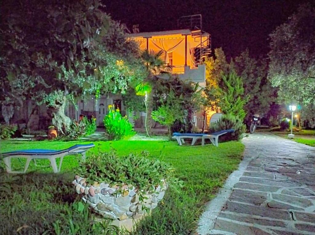 スカラ・ソティロスにあるSunray Apartmentsの夜の芝生のベンチ2つが置かれた公園