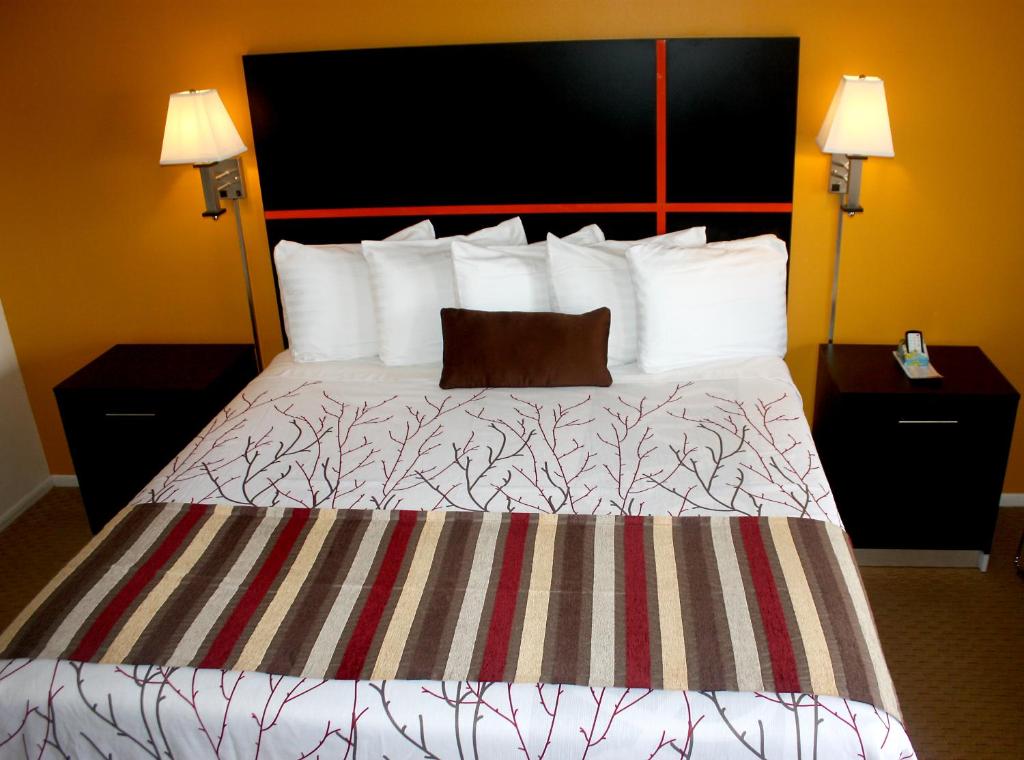 a hotel room with a bed with a pillow on it at Chaparral Motor Inn in Burlington