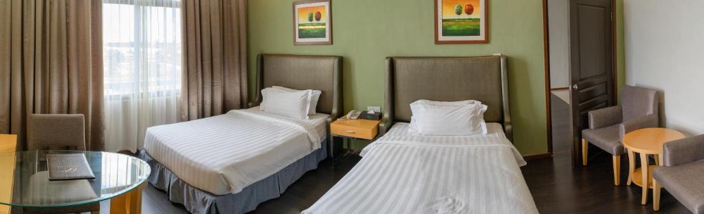 Postel nebo postele na pokoji v ubytování Seri Simanggang Hotel