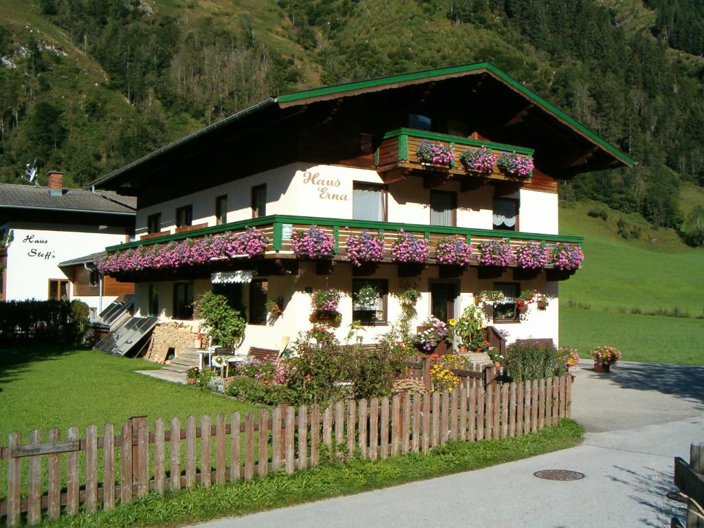 une maison avec des fleurs sur son côté dans l'établissement Haus Erna, à Rauris