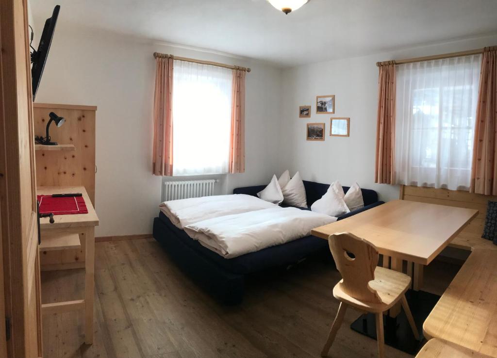 a living room with a bed and a table at Agriturismo Maso Larciunei in Selva di Val Gardena