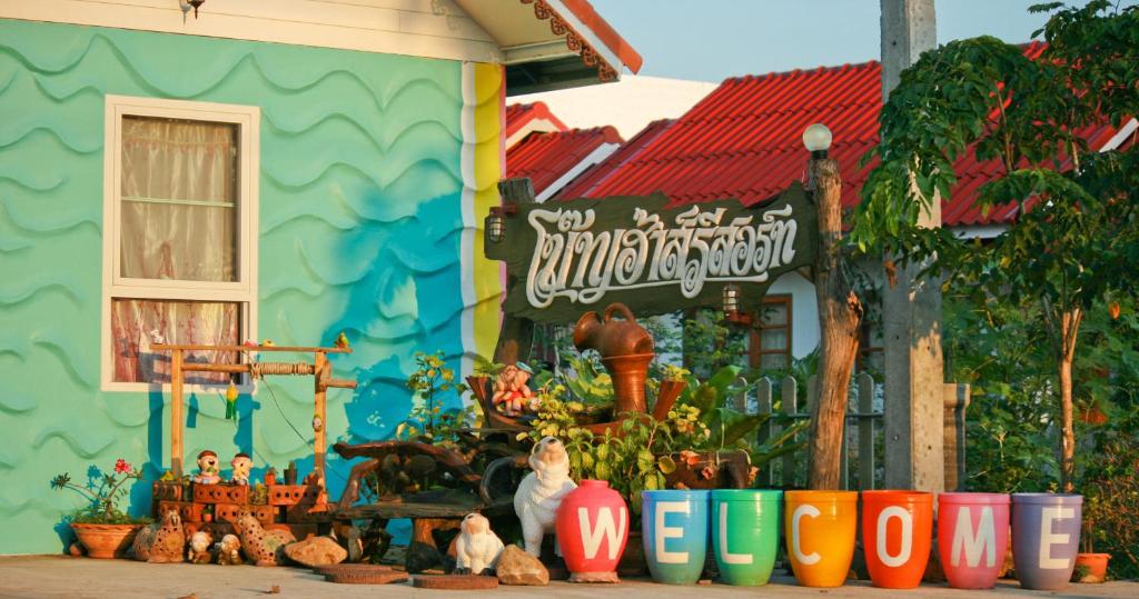 un edificio colorato con statuine di fronte di Boathouse Resort Suanphung a Suan Phung