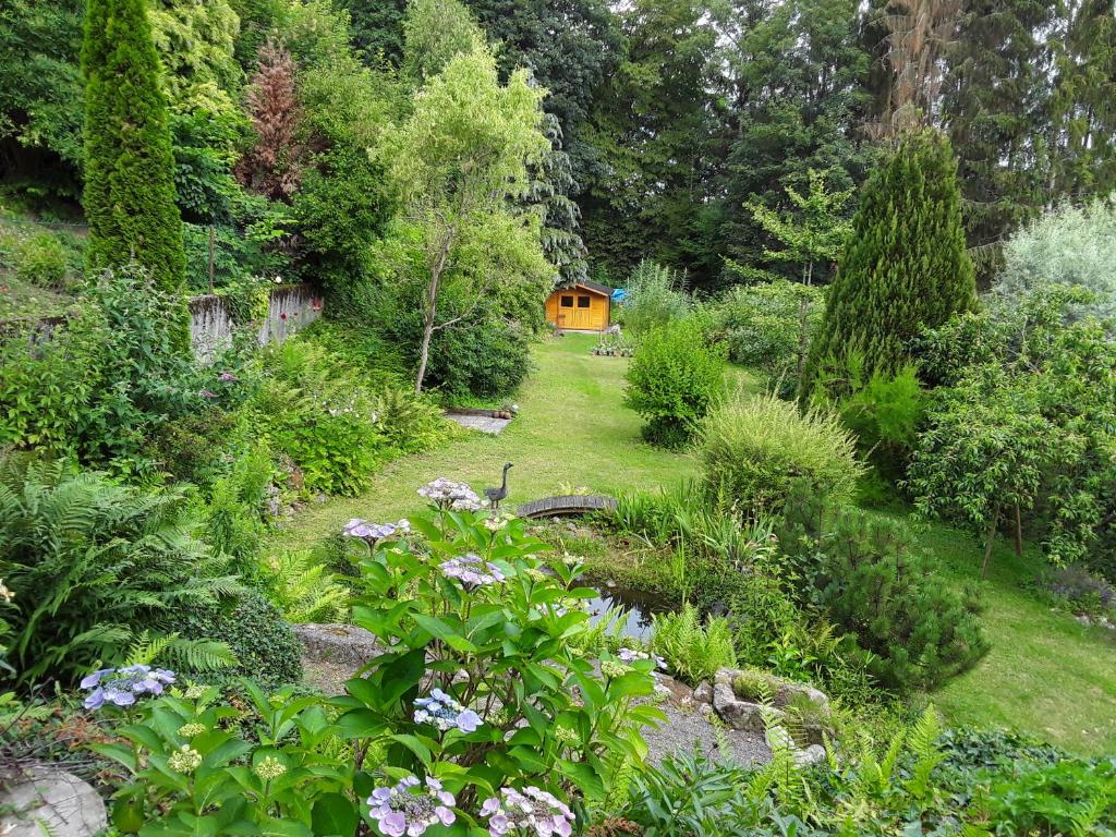 un jardin avec une maison jaune en arrière-plan dans l'établissement Ferienwohnung Hans, à Lindenfels