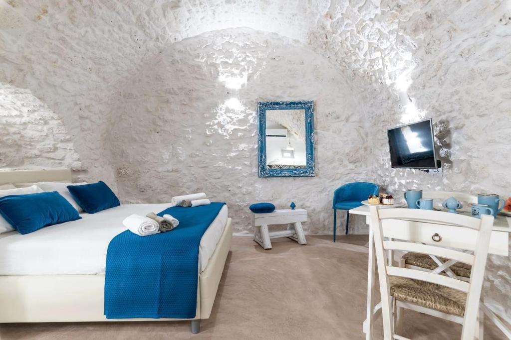 a bedroom with a bed and a vanity and a mirror at Azzurro Come Te - Ostuni in Ostuni