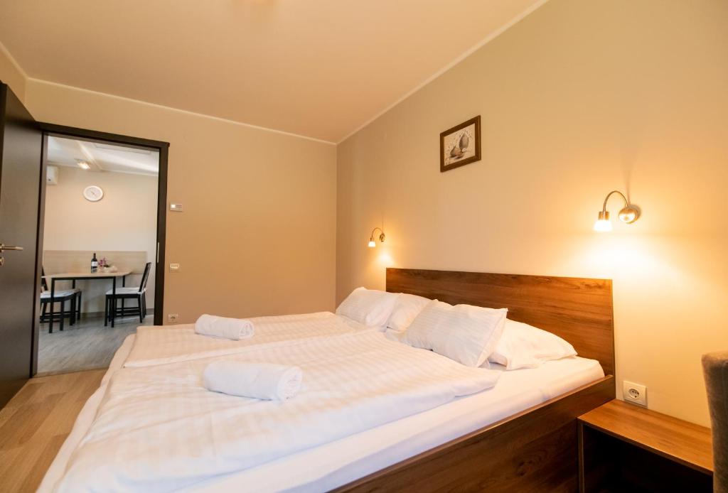 a bedroom with a large bed with two pillows on it at Dunazug Apartmanház in Dömös