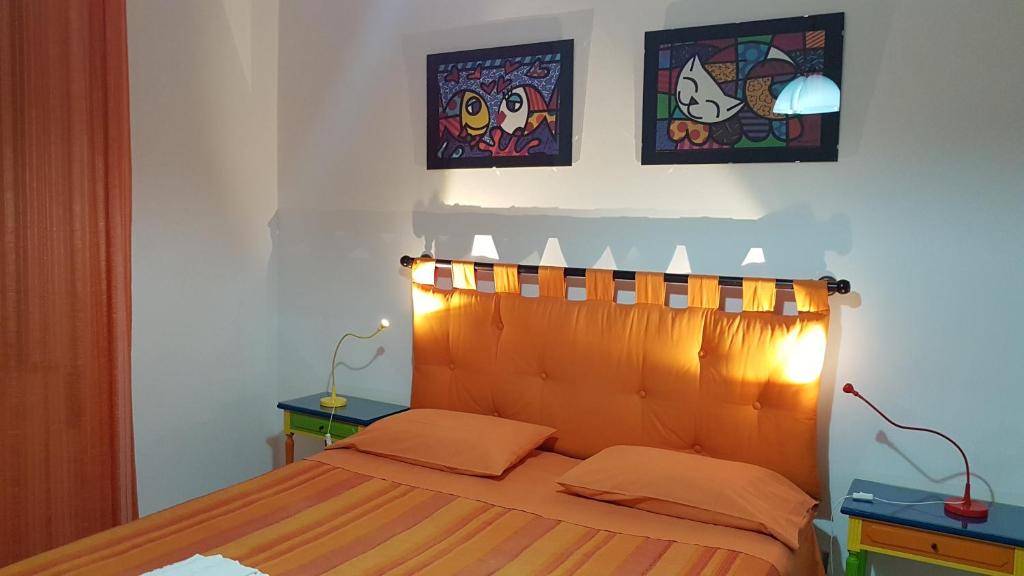 um quarto com uma cama com uma cabeceira em madeira e candeeiros em La Casina di Jo em Siena