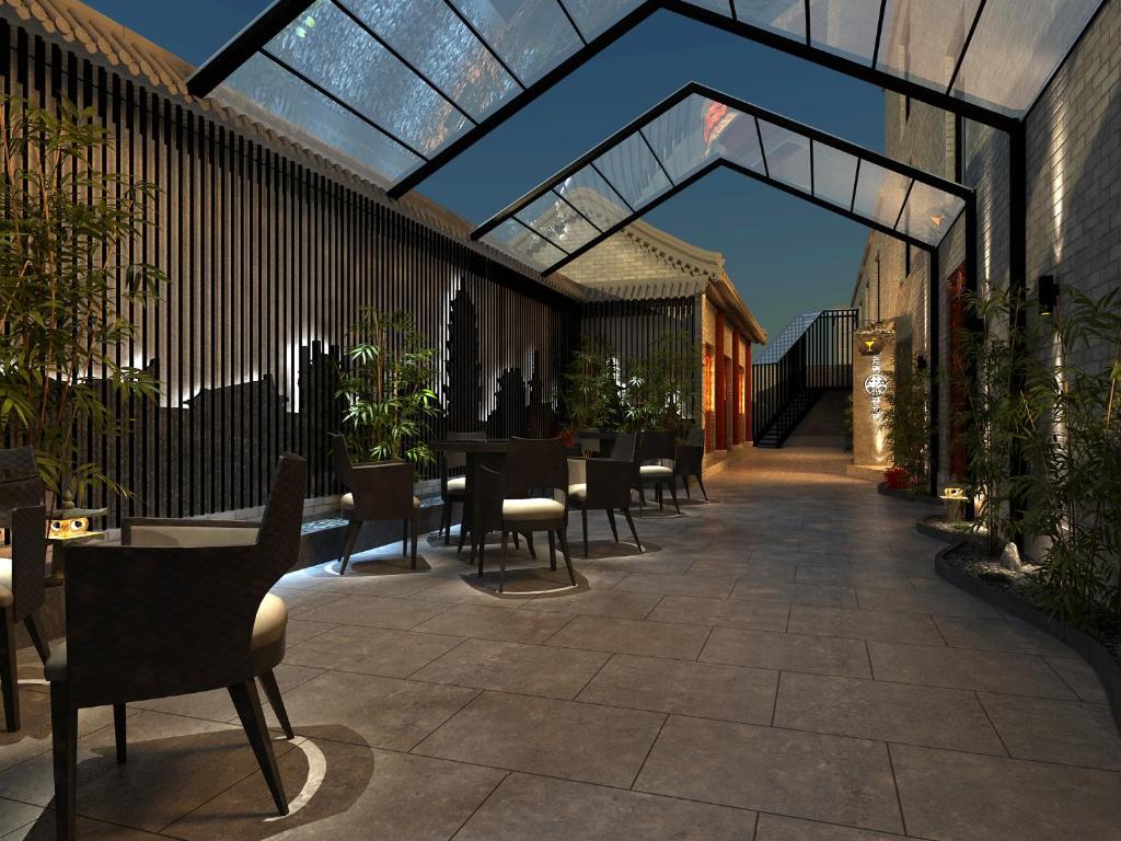 un patio avec des chaises et des tables dans un bâtiment dans l'établissement Happy Dragon City Culture Hotel -In the city center Close to Forbidden City&Wangfujing Street&Subway Nearby &free coffee & Free laundry&English speaking with tour services &Free WiFi unlimited for Western software, à Pékin