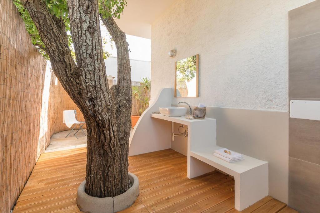 a bathroom with a tree in the middle of it at Villa Del Pero in Torre Lapillo