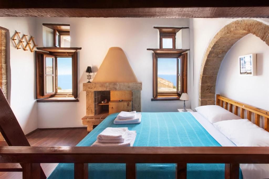 a bedroom with a large bed with a fireplace at Ypatia Cozy Castle Suite Apartment with Loft in Monemvasia