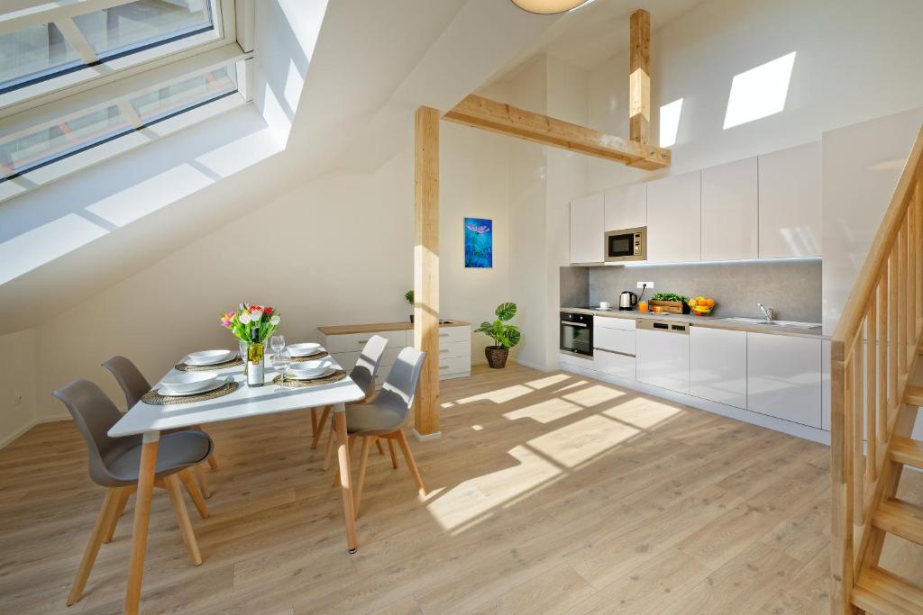 a kitchen and dining room with a table and chairs at DownTown Suites Jugoslavska in Prague