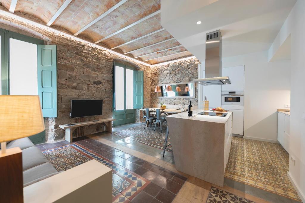 een keuken en een woonkamer met een bakstenen muur bij Bravissimo Mercaders, beautiful 3 bedroom apartment in Girona