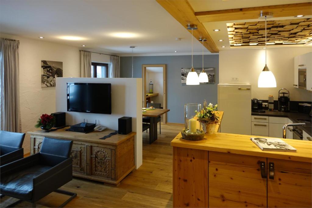 a kitchen and living room with a large television and a table at Ferienwohnungen Schmidbauer in Fischen