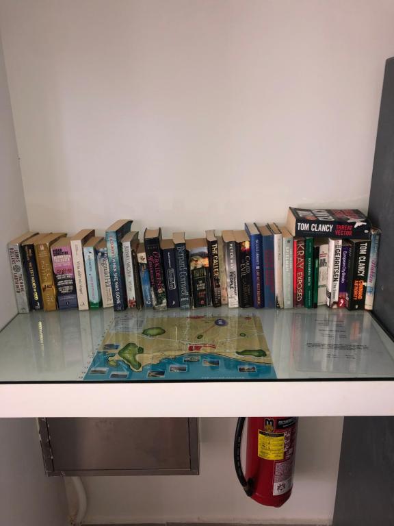 a row of books sitting on top of a shelf at Rose Hotel Faliraki in Faliraki