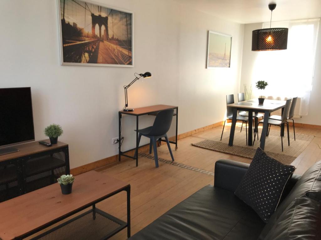 a living room with a couch and a table at Résidence Henri Dunant in Valenciennes