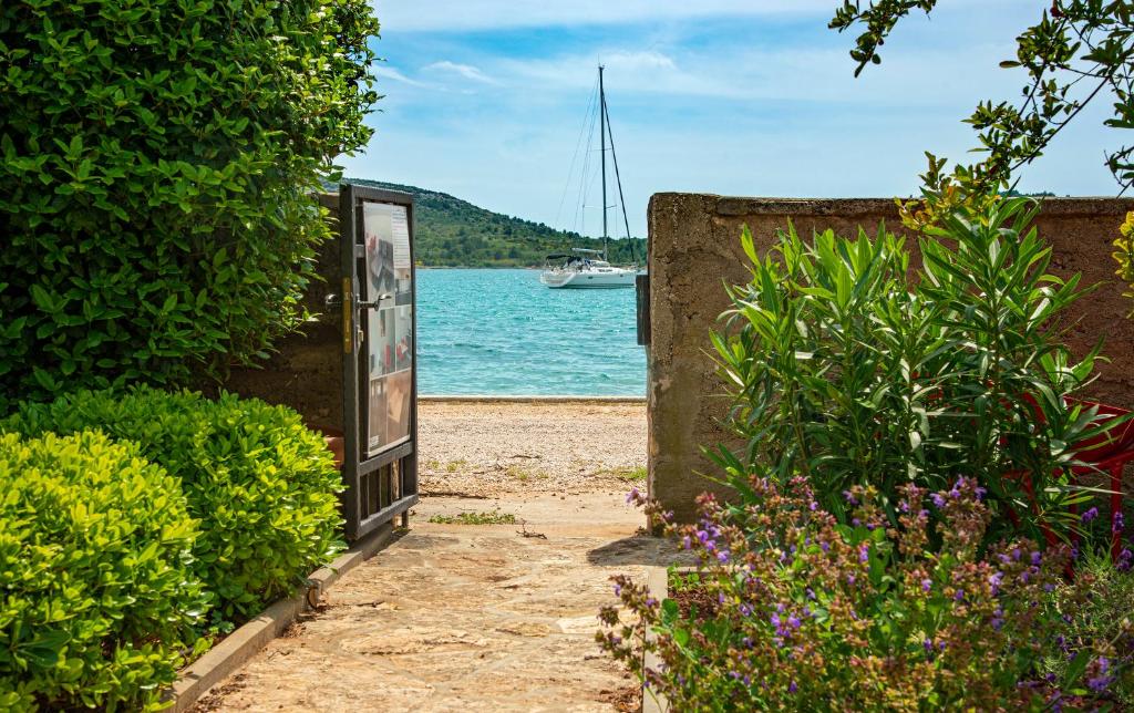 une porte menant à une masse d'eau avec un bateau dans l'établissement MIDAVkl, à Pirovac