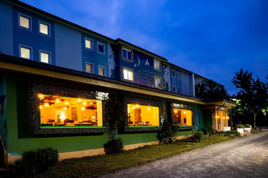 ein blaues Gebäude mit Lichtern in den Fenstern in der Unterkunft Elan Hotel in Limburg an der Lahn