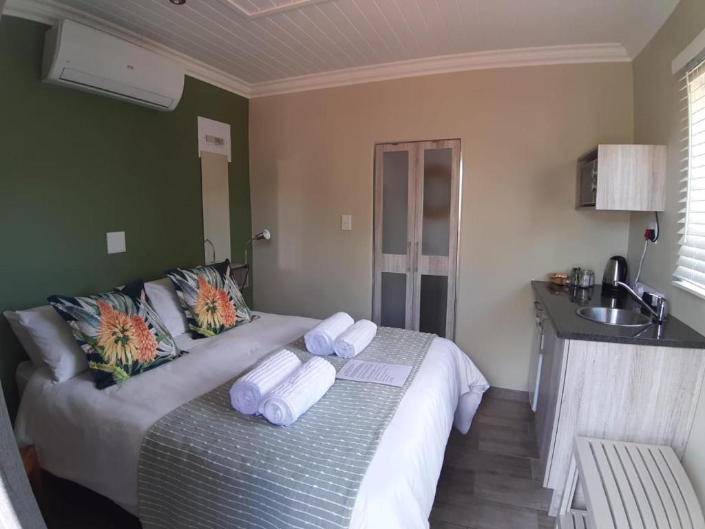 ein Schlafzimmer mit einem Bett mit Handtüchern darauf in der Unterkunft Gathering Guesthouse - Aloe room in Bloemfontein