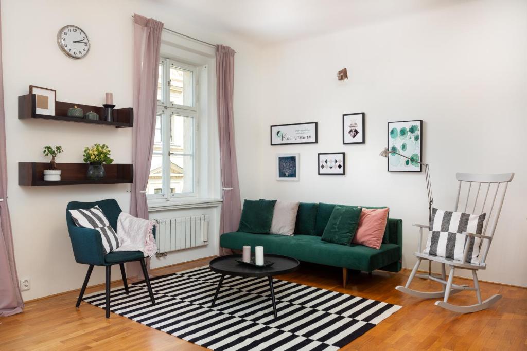 salon z zieloną kanapą i 2 krzesłami w obiekcie City Center Cozy Apartments w Pradze
