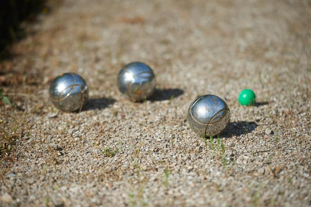 a group of metal balls sitting on the ground at La Grande Maison De Nans in Nans-les-Pins