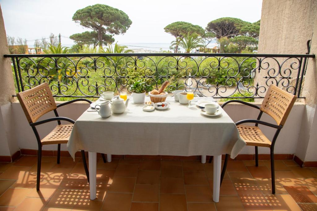 a table with a white table cloth on a balcony at Hôtel Saint Andre in Saint-Tropez