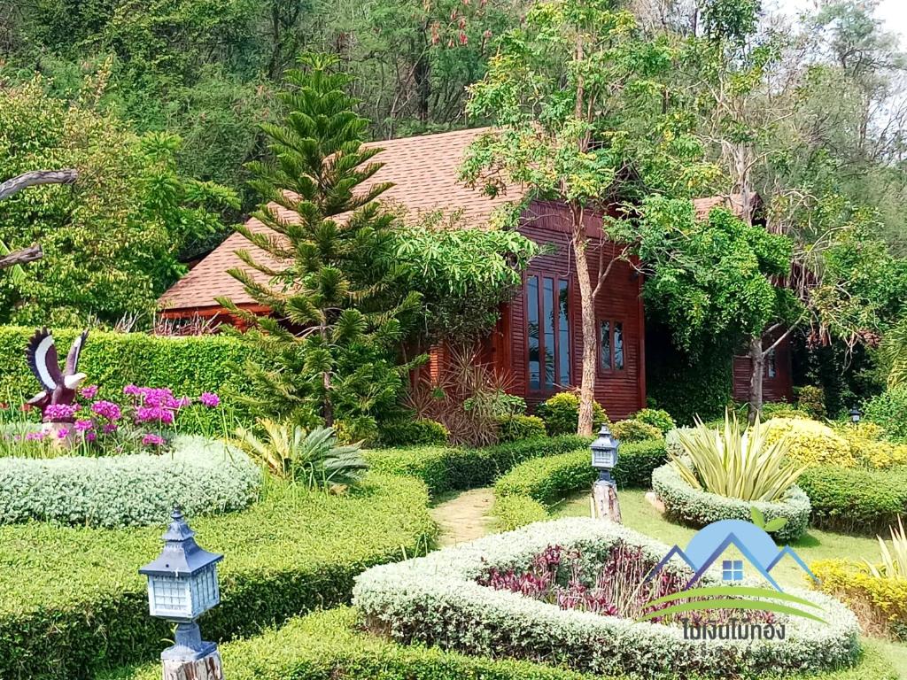 een tuin voor een huis met bloemen en planten bij Maingern Maithong Resort in Sara Buri