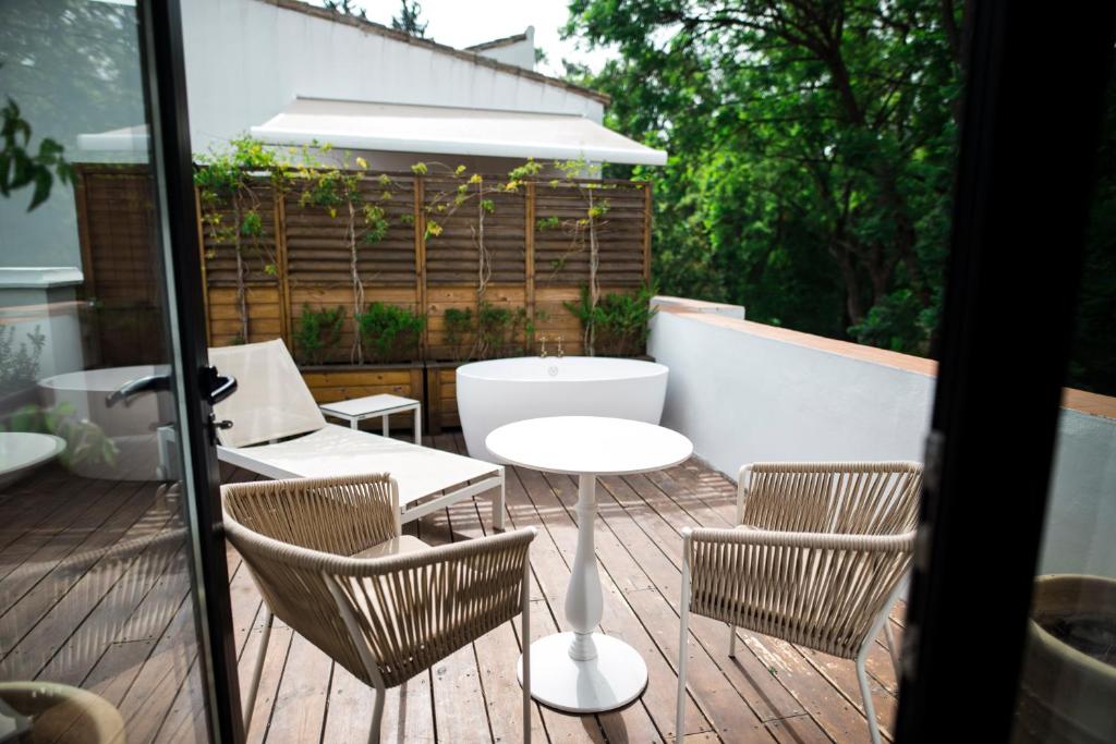 a patio with a table and chairs on a deck at Hotel Legado Alcazar in Seville
