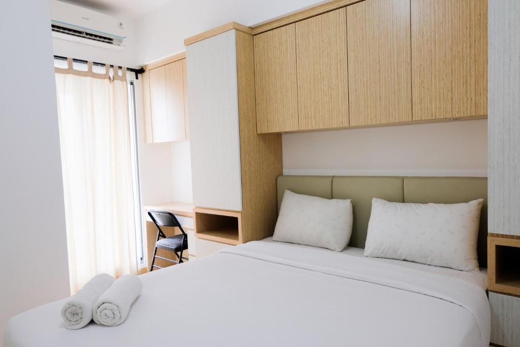 a bedroom with a bed with two white towels on it at Comfy 2BR Apartment at M-Town Residence By Travelio in Tangerang