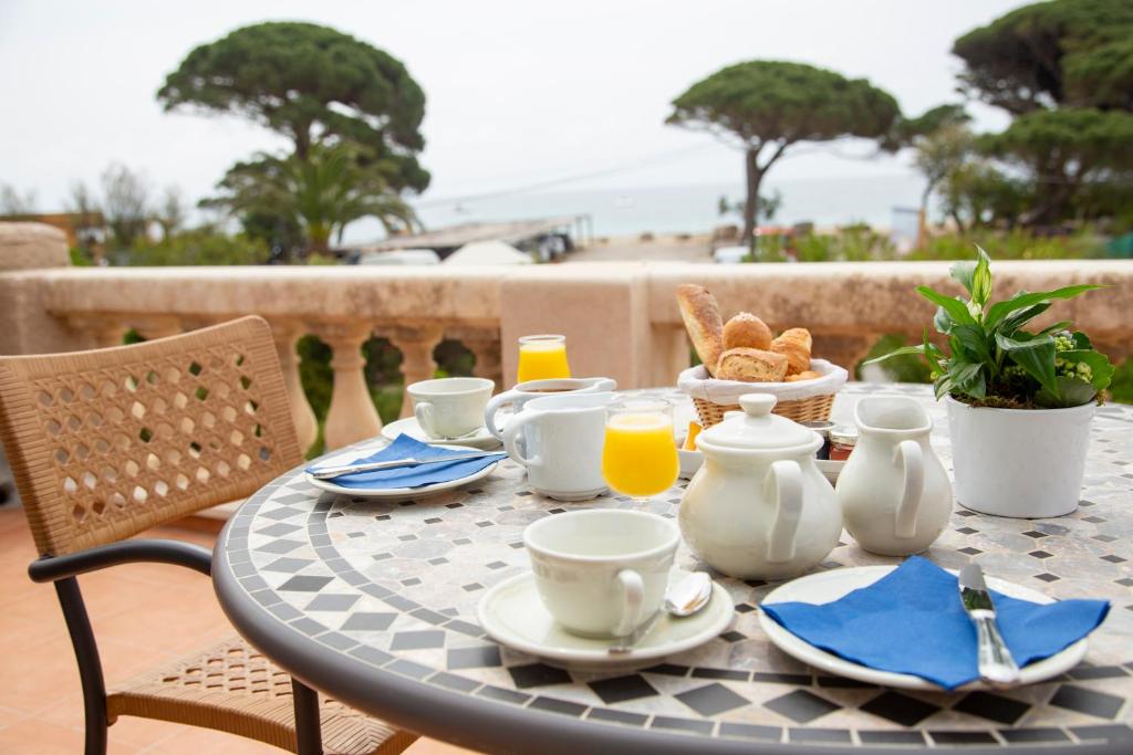a table with a breakfast of coffee and orange juice at Hôtel Saint Andre in Saint-Tropez