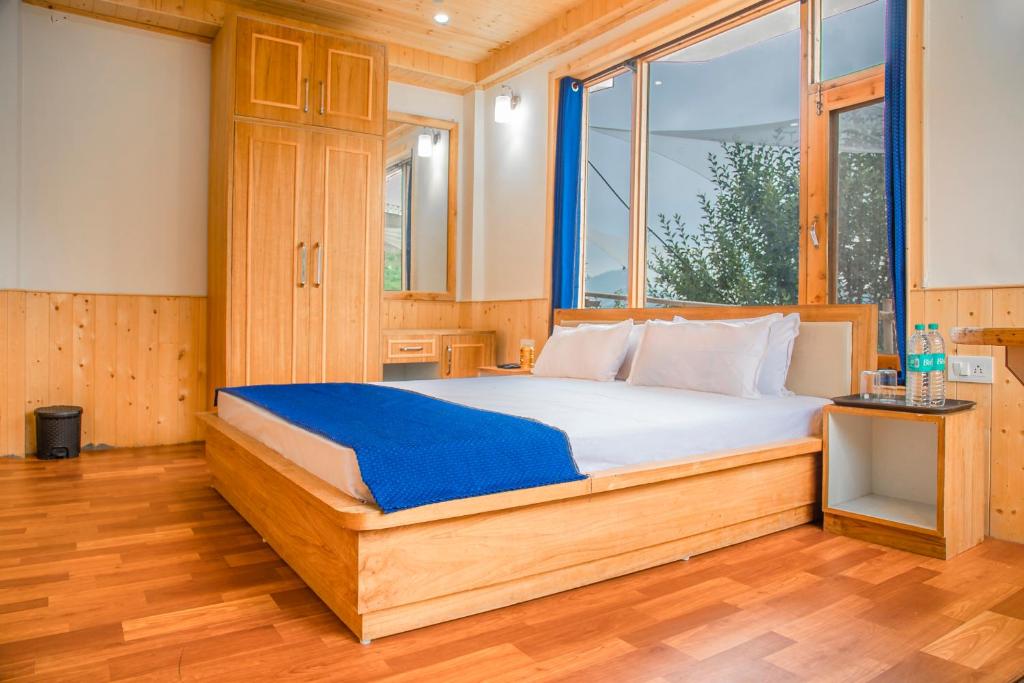 a bedroom with a bed with a large window at LivingStone Hillswood Orchard Stay in Cheog