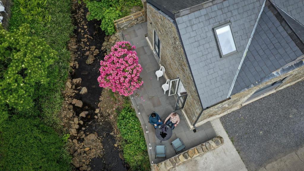 una vista aérea de un patio con flores rosas en Swansea Valley Holiday Cottages, en Cilybebyll