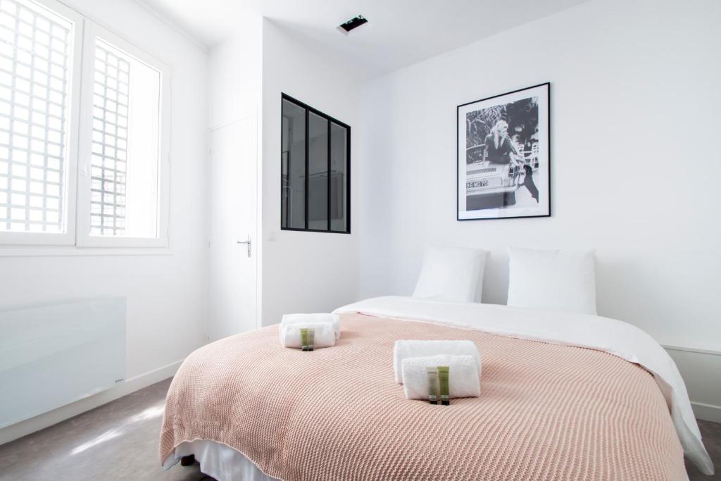 - une chambre blanche dotée d'un lit avec deux bougies dans l'établissement Dreamyflat - Eiffel tower, à Paris