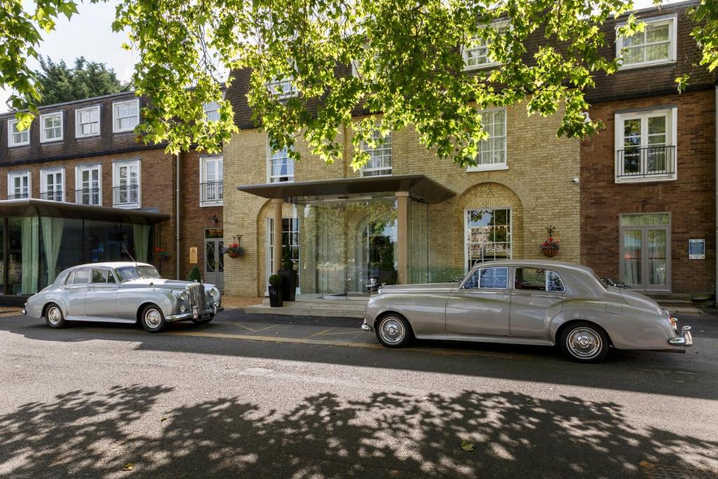 two old cars parked in front of a building at Gonville Hotel in Cambridge