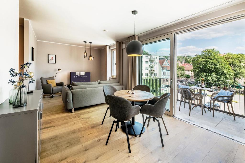 een woonkamer met een tafel en stoelen bij Suites MITTE - Aparthotel in Eisenach