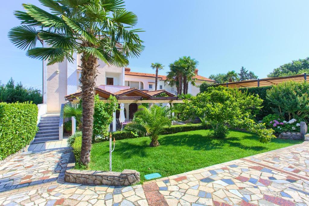 una casa con una palmera en el patio en Villa Palma, en Malinska